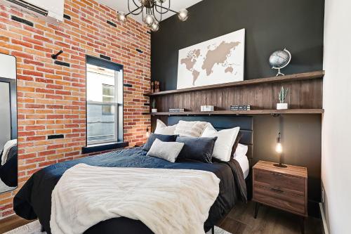 a bedroom with a brick wall and a large bed at The Brick & Beam Boutique Hotel in Collingwood