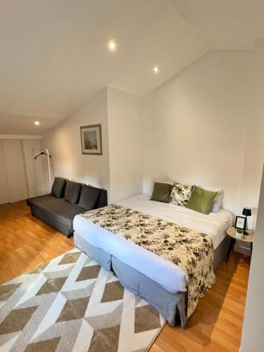 a bedroom with a bed and a couch at Grande Maison XXL in Villiers-le-Bel