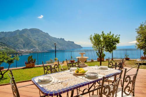 a table and chairs with a view of the water at Villa Il Lupo Felice - Panoramic Sea View Villa, Ravello in Ravello