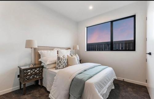 a bedroom with a large bed and a window at Unique Stays in Auckland
