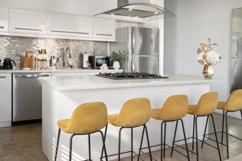 a kitchen with a counter with four stools at Angel City 1 bedroom Apartment in Los Angeles