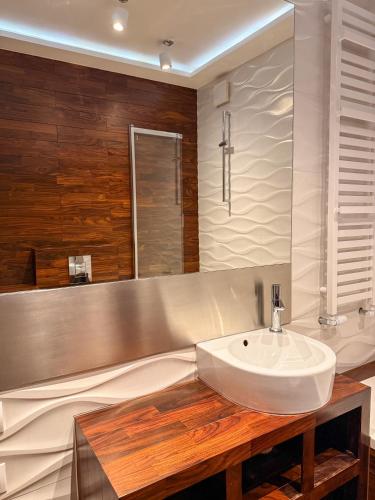 a bathroom with a white sink and a mirror at Home4You free park in Krakow