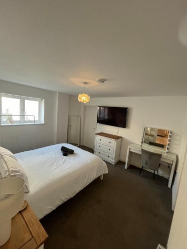 a bedroom with a bed and a desk and a television at An Treth in Bude
