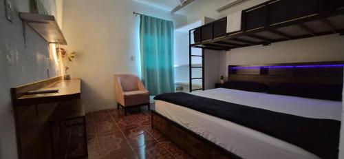 a bedroom with a bed and a desk and a chair at Residencia G in Champotón