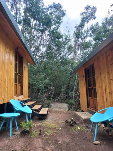 a cabin with blue tables and benches in the woods at Bosque Venado de Oro in Guatavita