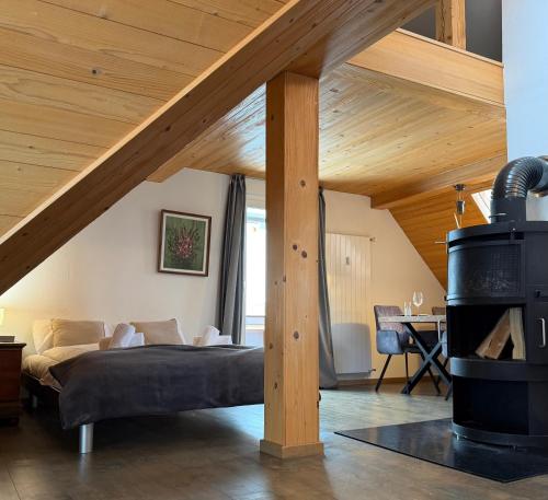 ein Schlafzimmer mit einem Bett in einem Zimmer mit Holzdecke in der Unterkunft Waterfall View in Kandersteg