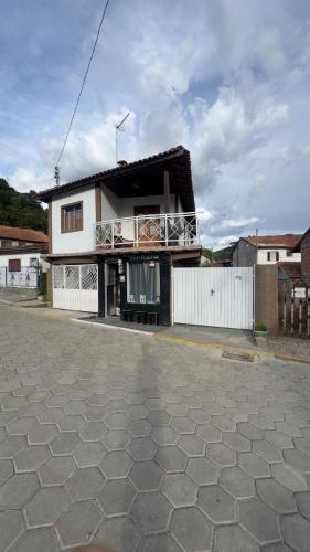 a house with a balcony on the side of a street at AP Temporada Monte Verde in Monte Verde