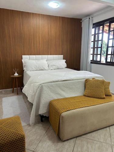 a bedroom with a large bed and a chair at Recanto da barra in Ilha do Bom Jardim