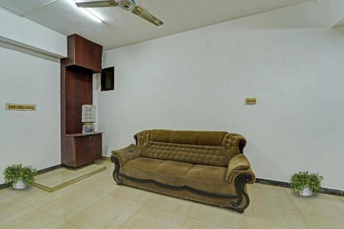 a living room with a couch in a room at Hotel O Grand Pallavaram in Chennai