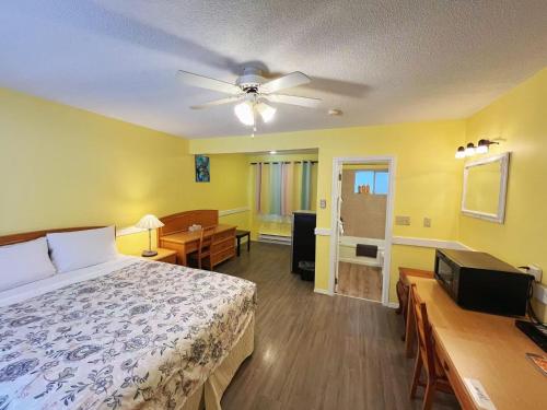 a bedroom with a bed and a ceiling fan at Rivermount Motel in Little Fort