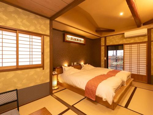 a bedroom with a bed and a sign on the wall at Wa no Yado Sagiritei in Yufu