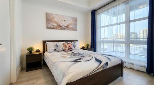 a bedroom with a bed and a large window at Family Stylish 1BR and Den Condo -Apartment with City View, Downtown, Balcony, Free Parking, In-Suite Laundry! in Calgary