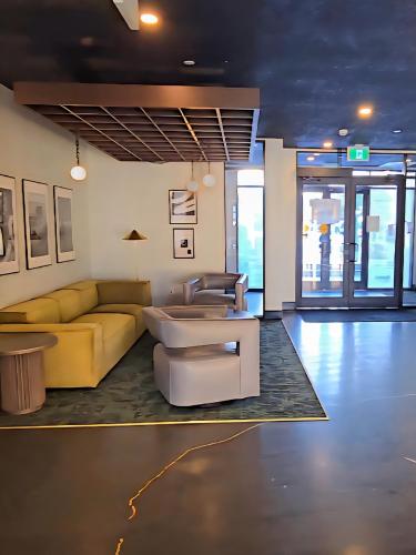 a living room with a couch and a table at Family Stylish 1BR and Den Condo -Apartment with City View, Downtown, Balcony, Free Parking, In-Suite Laundry! in Calgary