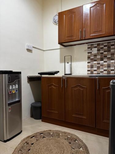 a kitchen with wooden cabinets and a refrigerator at Modern Style Designer Studio Apartment in Abu Dhabi