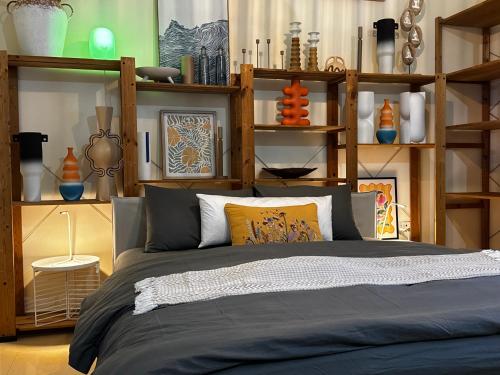 a bedroom with a bed with lots of shelves at Modern Style Designer Studio Apartment in Abu Dhabi