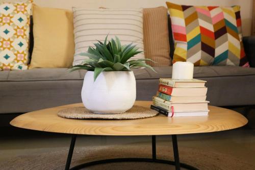 a vase sitting on a coffee table with books at Modern Style Designer Studio Apartment in Abu Dhabi