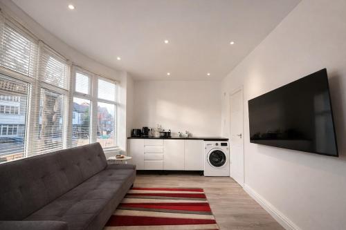 a living room with a couch and a washing machine at Cozy 1-Bed Flat Ideal for Short & Long Stays in Manchester