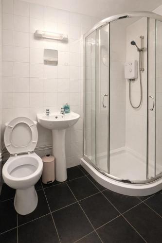 a bathroom with a toilet and a shower and a sink at Cozy 1-Bed Flat Ideal for Short & Long Stays in Manchester