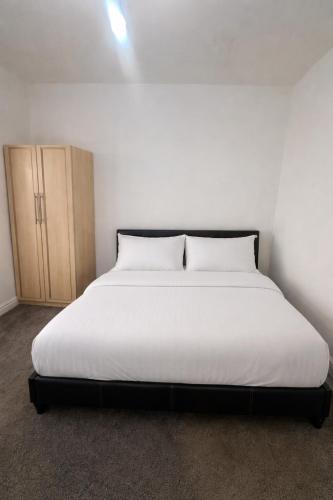 a white bed with two pillows in a room at Cozy 1-Bed Flat Ideal for Short & Long Stays in Manchester