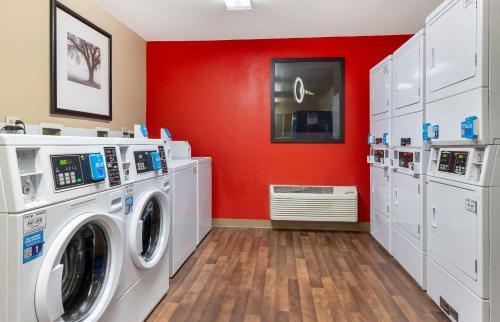 a laundry room with a washing machine and red walls at Extended Stay America Suites - Cincinnati - Florence - Turfway Rd in Florence