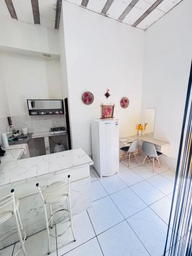 a kitchen with a refrigerator and a table and chairs at Chaves Maguari Locação por Temporada- Ananindeua in Ananindeua