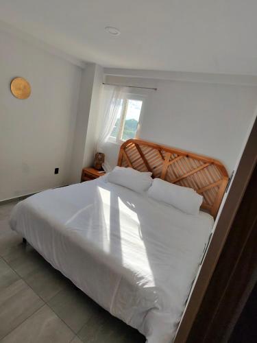 a large white bed in a room with a window at HABITACIÓN Torres Palmas alberca, vista al mar, Roof Top VIP in Boca del Río