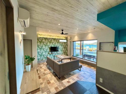 a living room with a couch and a tv at East Villa Shimanami Mukaishima seafront in Onomichi