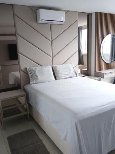 a bedroom with a large white bed with a headboard at Sonatta in Torres