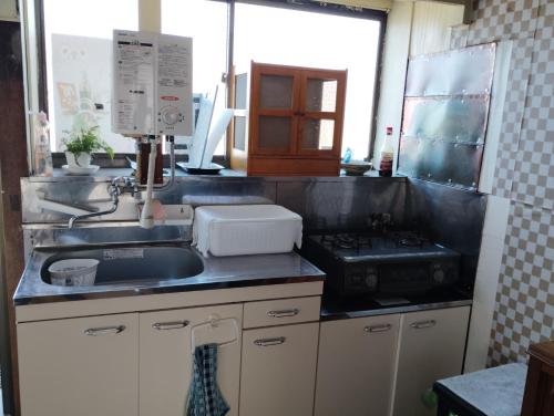 a kitchen with a sink and a stove at T&T Fujiyama SAKURA in Fujiyoshida