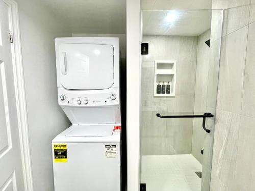 a small refrigerator with a dryer on top of it at Violet Escape Modern Apt 1B 1B, Kitchen, Parking in Richmond Hill