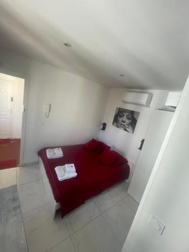 a bedroom with a red bed in a white room at Sweet Home Marceau - 6 studios hyper centre proche de la mer et du palais in Cannes
