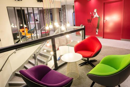 a lobby with colorful chairs and a glass table at Hôtel Paris Vaugirard in Paris
