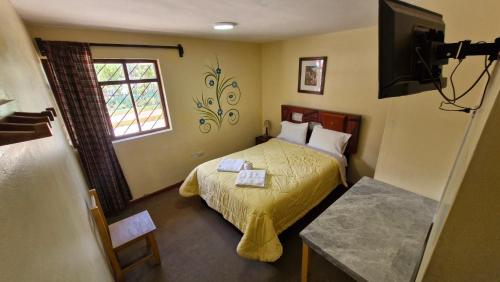 a small bedroom with a bed and a television at Mirador Backpackers B&B in Huaraz