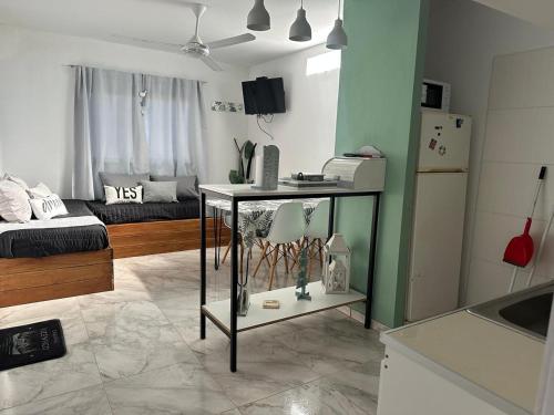 a kitchen and living room with a table and a refrigerator at Cabañas Vicentico in Mina Clavero