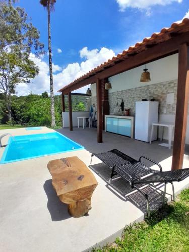 a patio with a table and a kitchen and a pool at Mansion in the mountains in Teresópolis