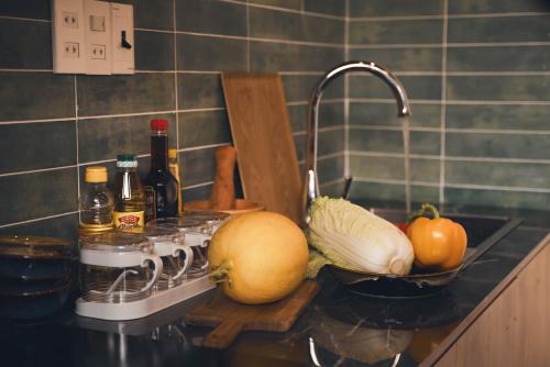 a kitchen counter with fruits and vegetables on a sink at Mộc An Homestay in Kon Rung (1)