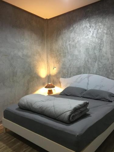 a bedroom with a bed with a lamp on it at Fahad Calm House in Ko Lanta