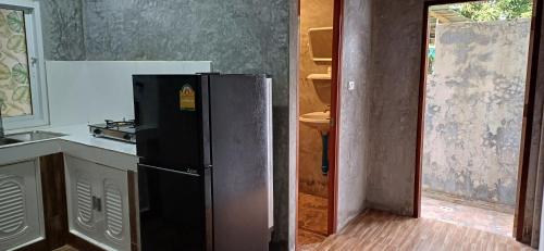 a kitchen with a black refrigerator in a room at Fahad Calm House in Ko Lanta