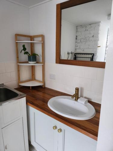 a bathroom with a sink and a mirror at Pleasant View Apartment - Ocean View in Caloundra