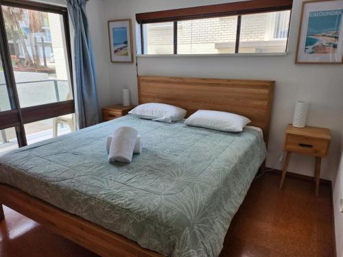 a bedroom with a bed with a hat on it at Pleasant View Apartment - Ocean View in Caloundra