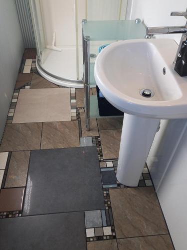 a bathroom with a white sink and a shower at Round About in Parore