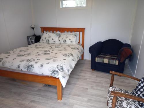 a bedroom with a bed and a chair at Round About in Parore