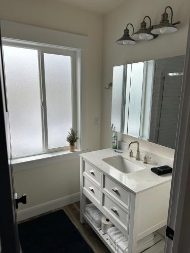 a bathroom with a sink and a large mirror at Scenic Farmhouse in Riverton