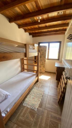 a room with two bunk beds and a window at Hostel e Camping Vale Mirante da Rocha in Timbe do Sul