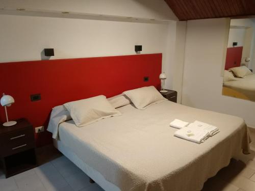a bedroom with a large bed with two towels on it at Hotel Cristal in Viedma