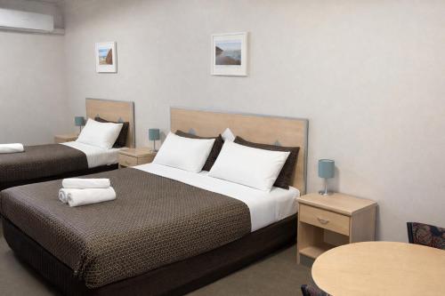 a hotel room with two beds and a table at Highway One Motel in Ceduna