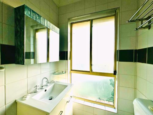 a bathroom with a sink and a window at Aussie Rest Motel in Cessnock