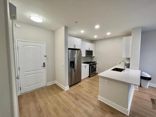 a kitchen with white cabinets and a white door at Miracle Mile Apartments in Los Angeles