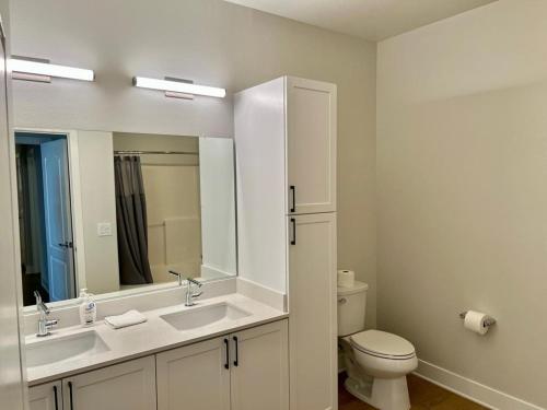 a bathroom with a sink and a toilet and a mirror at Miracle Mile Apartments in Los Angeles