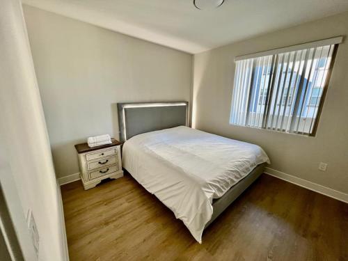 a small bedroom with a bed and a window at Miracle Mile Apartments in Los Angeles